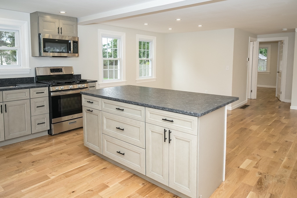 a kitchen with granite countertop white cabinets and stainless steel appliances