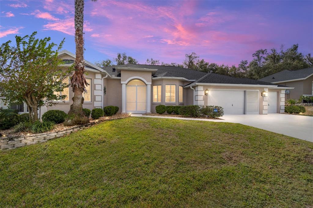 a front view of a house with a yard and a garage