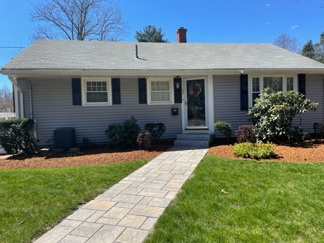 a front view of a house with a yard and potted plants