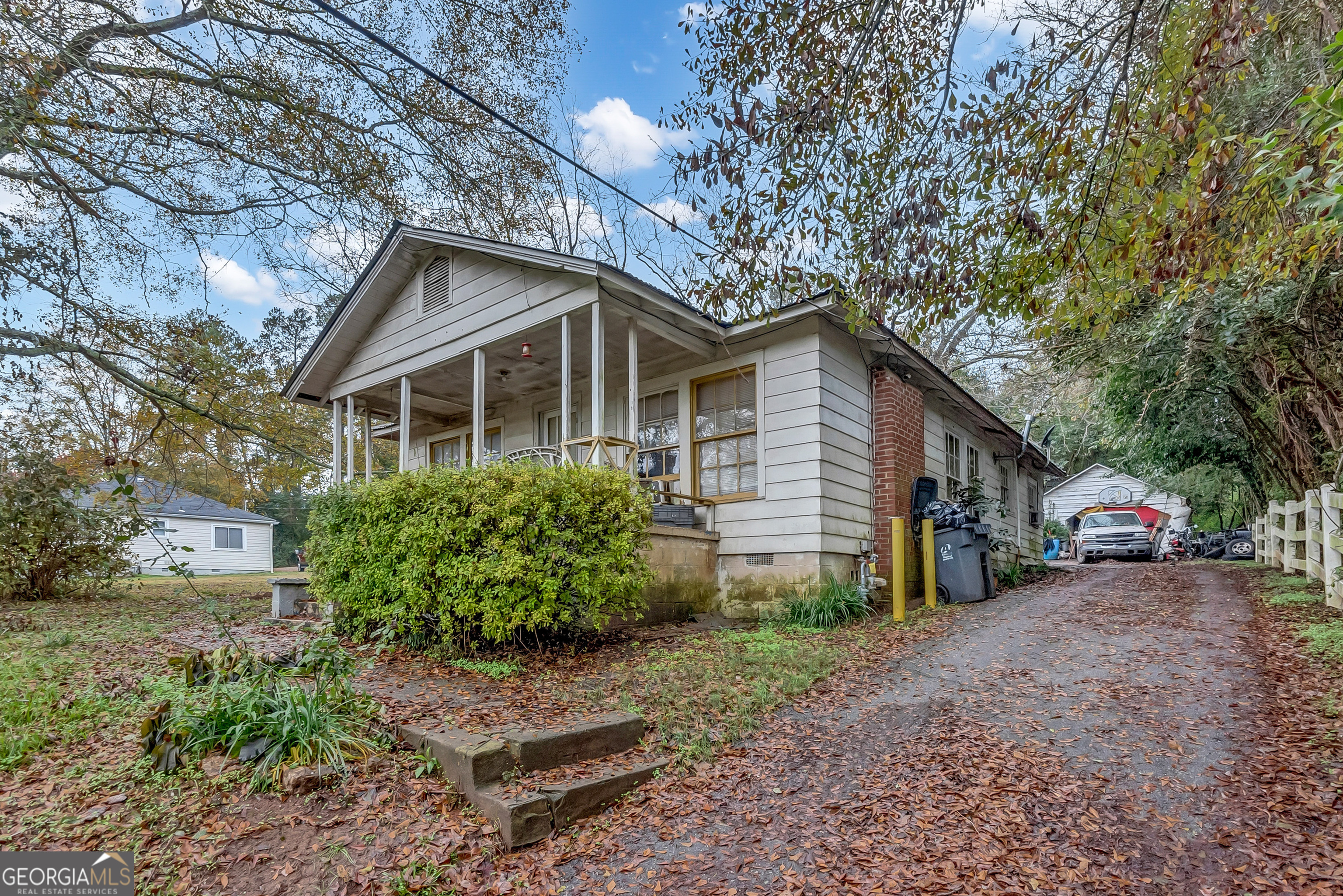 a view of a house with a yard and large trees