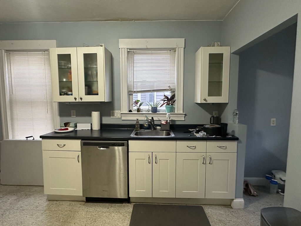 a kitchen with stainless steel appliances granite countertop a sink and a stove next to a window