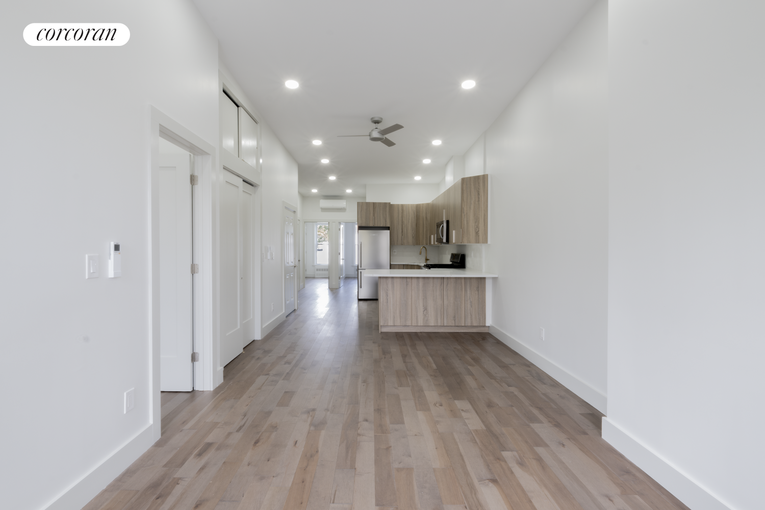 a view of kitchen with cabinets stainless steel appliances and wooden floor