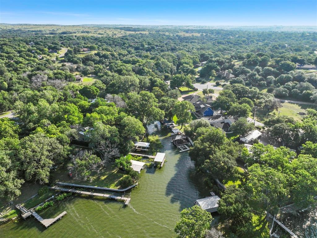 an aerial view of residential houses with outdoor space and trees