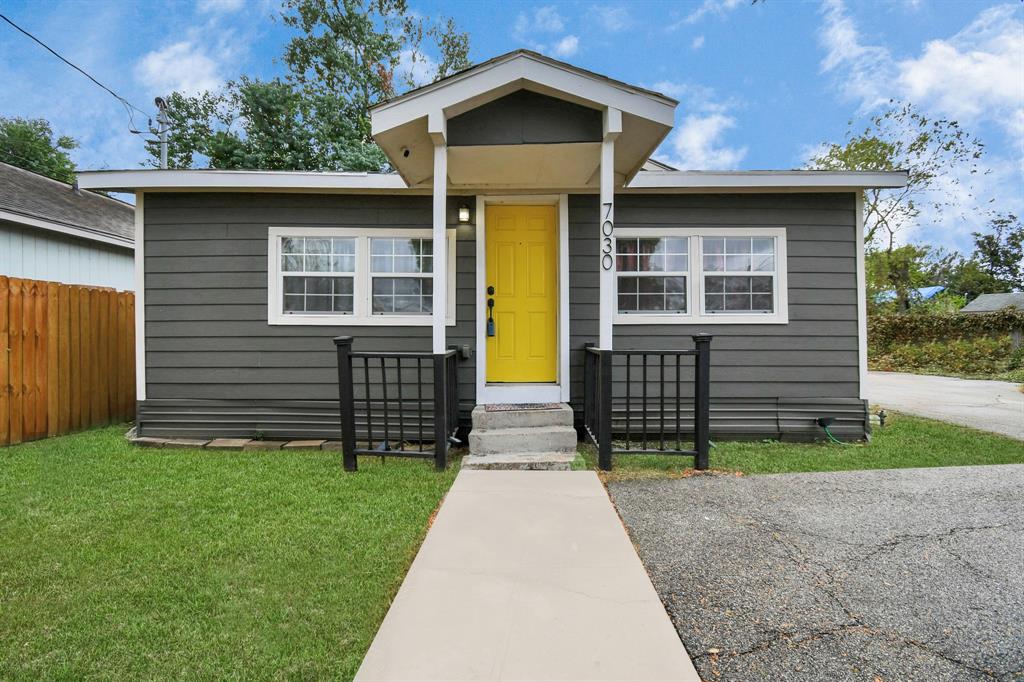 Charming single-story home with a striking yellow door, waiting for a family to enjoy.