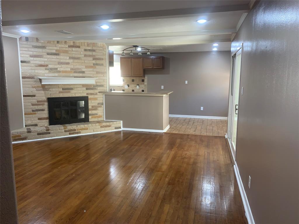 a view of a livingroom with wooden floor and a fireplace