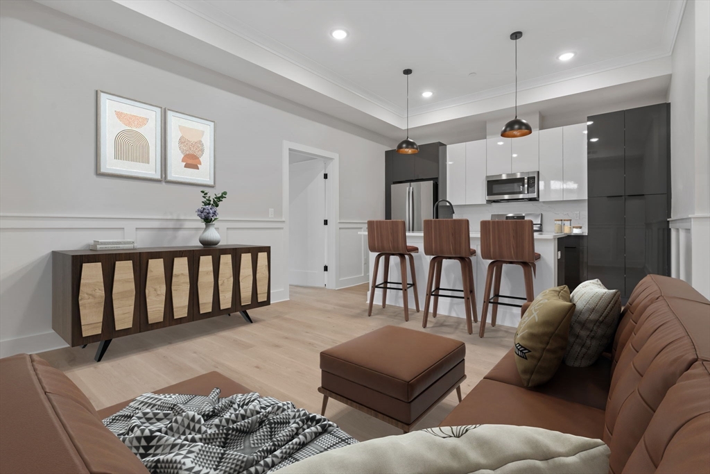 a living room with furniture a rug and kitchen view