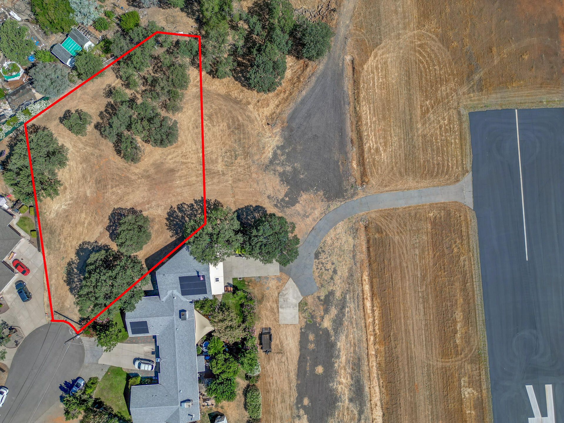 an aerial view of a house with a yard and large trees