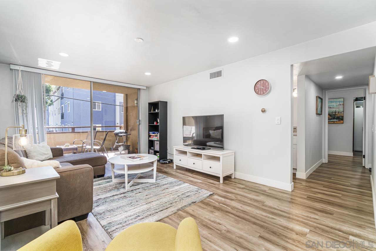 a living room with furniture flat screen tv and large window