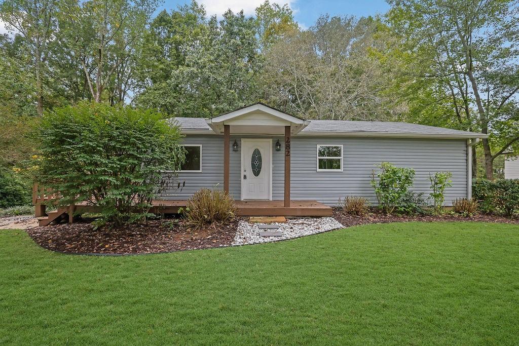 a backyard of a house with plants and large trees