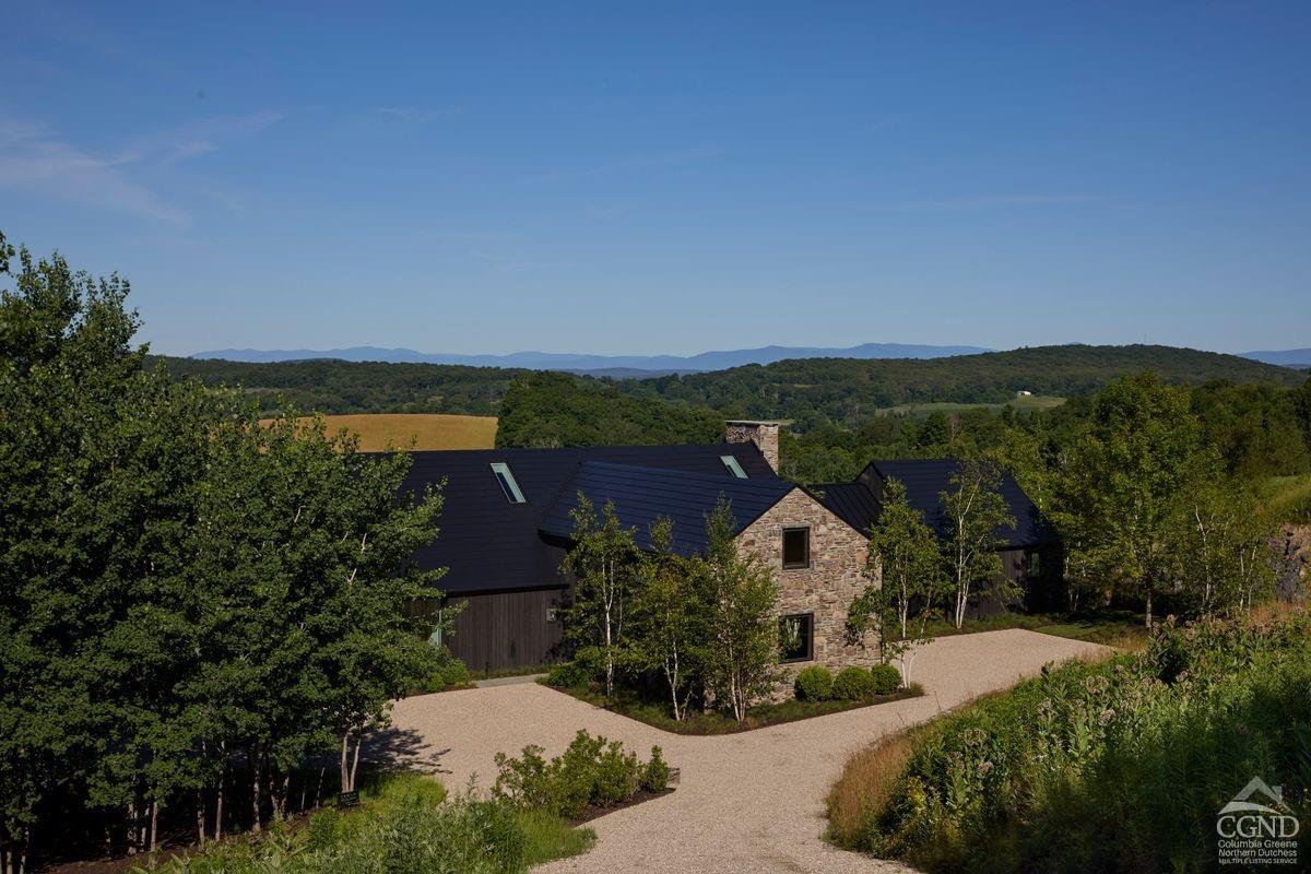 an aerial view of a house with a garden and lake view