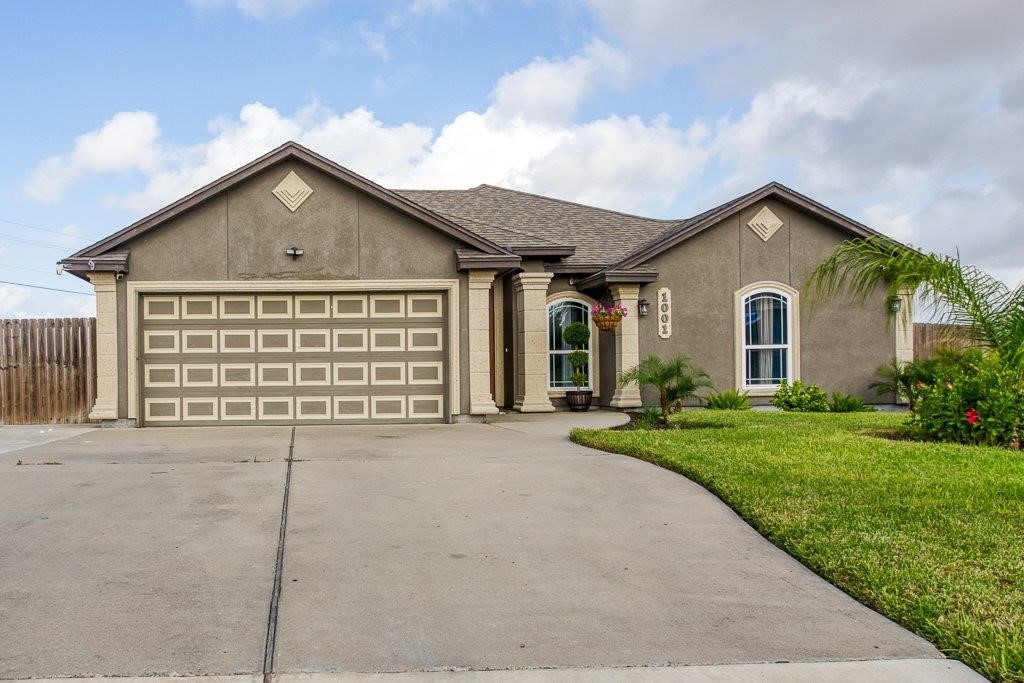 a view of a house with a yard and garage