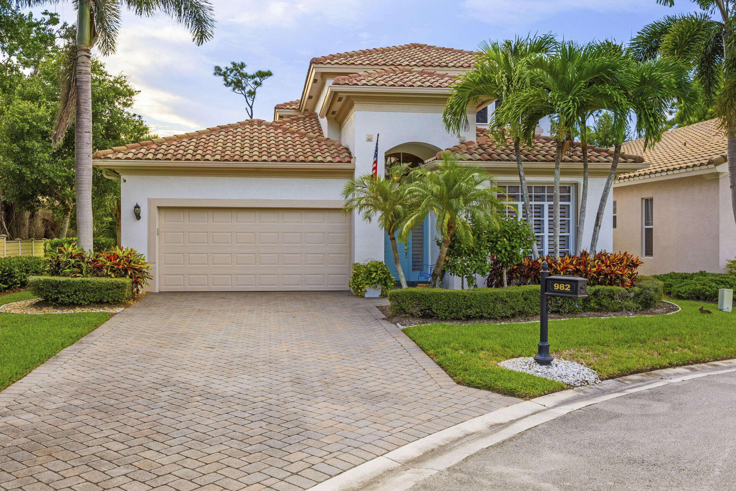 a front view of a house with a garden and garage