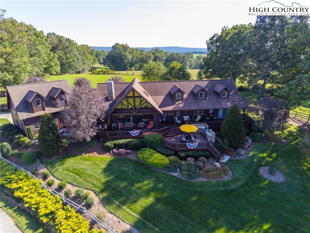 an aerial view of house with swimming pool and yard