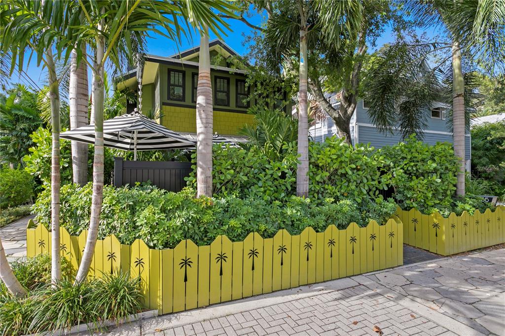 a front view of a house with a yard and potted plants