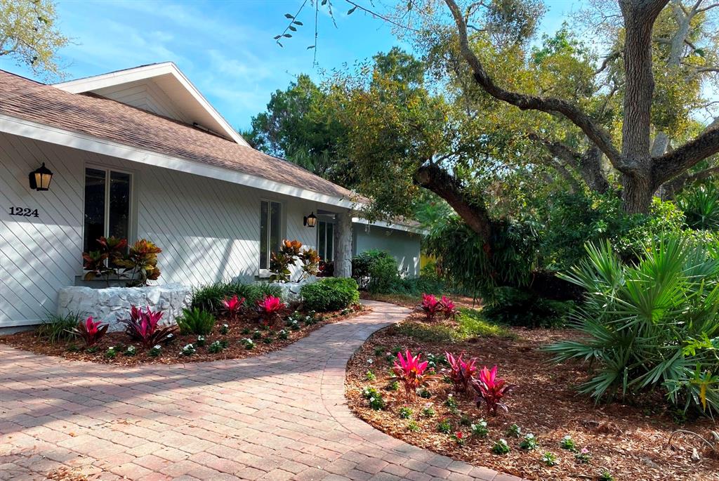 a front view of a house with flower around