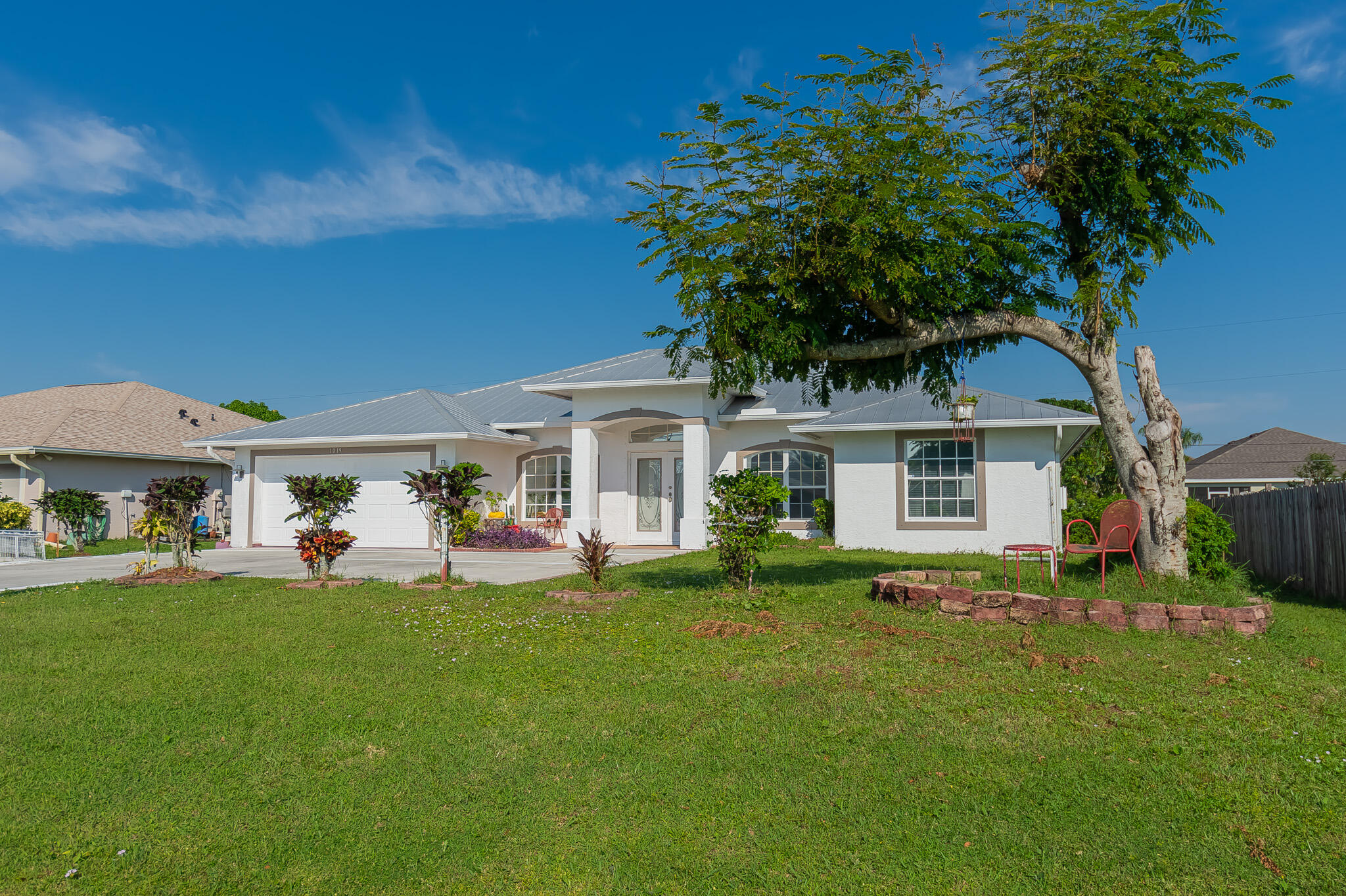 a front view of a house with a garden and trees