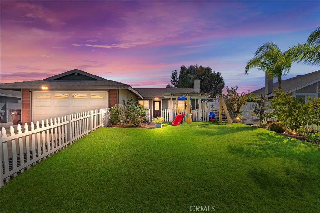 a view of a house with a yard and a garage