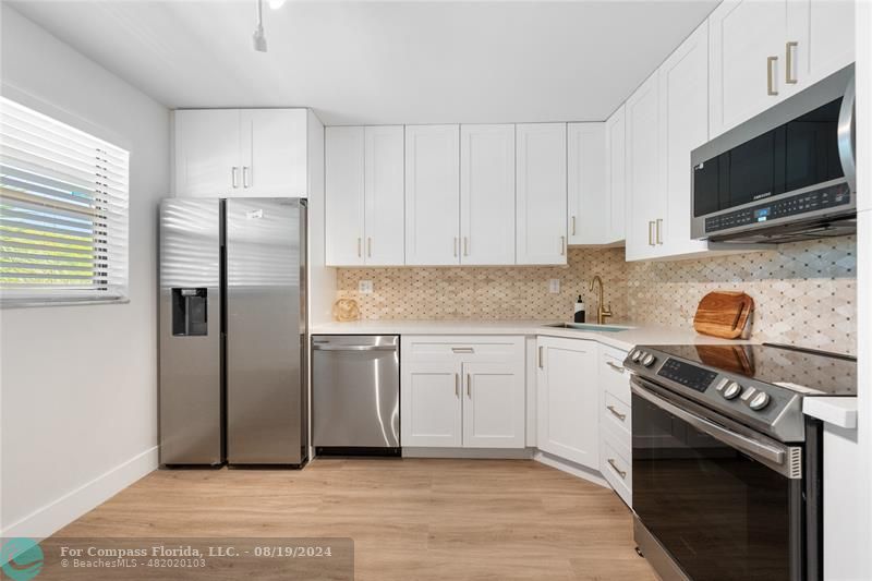 a kitchen with stainless steel appliances a stove a sink and a microwave