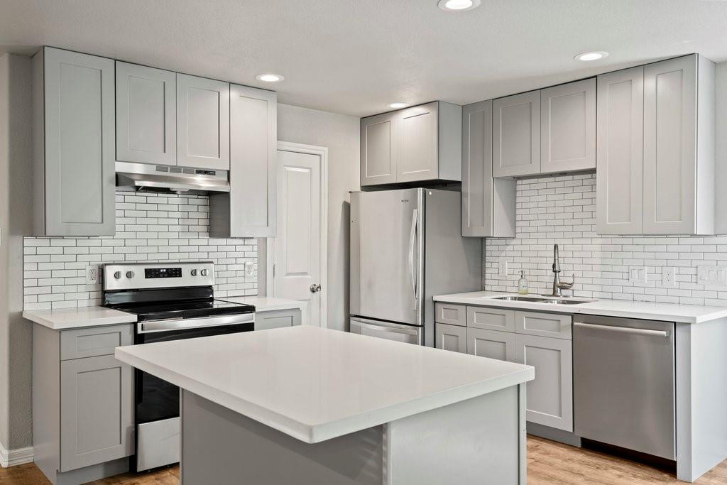 a kitchen with kitchen island a sink appliances and cabinets