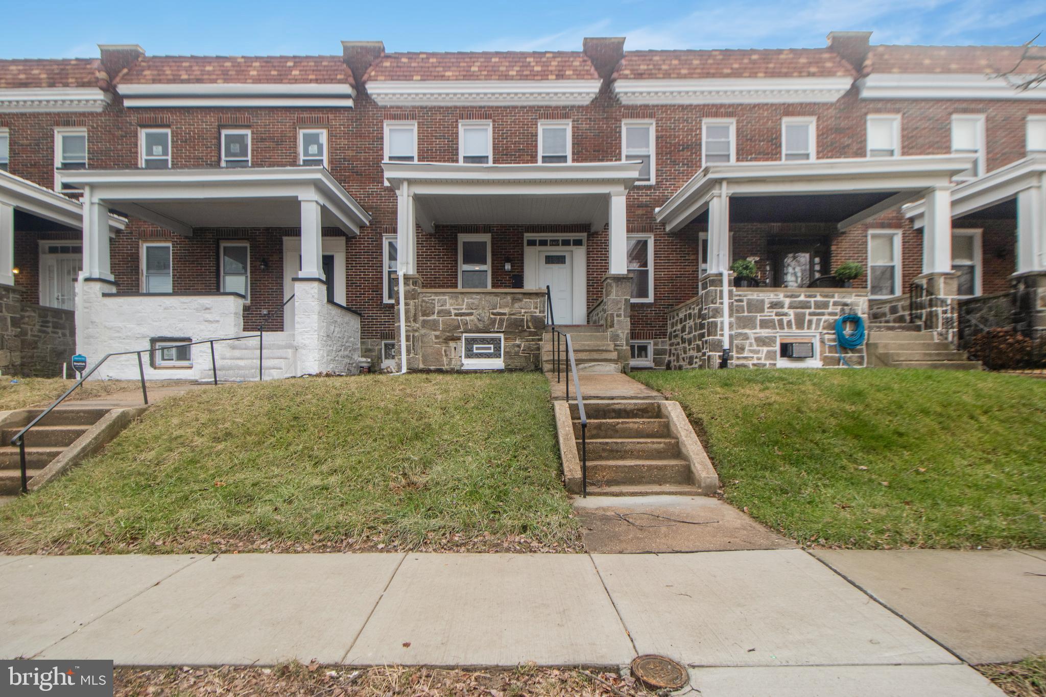 front view of a brick house with a yard