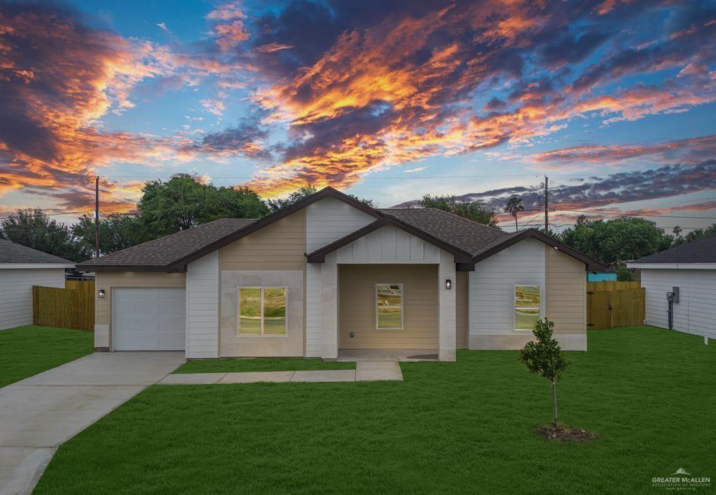 Single story home featuring a garage and a yard