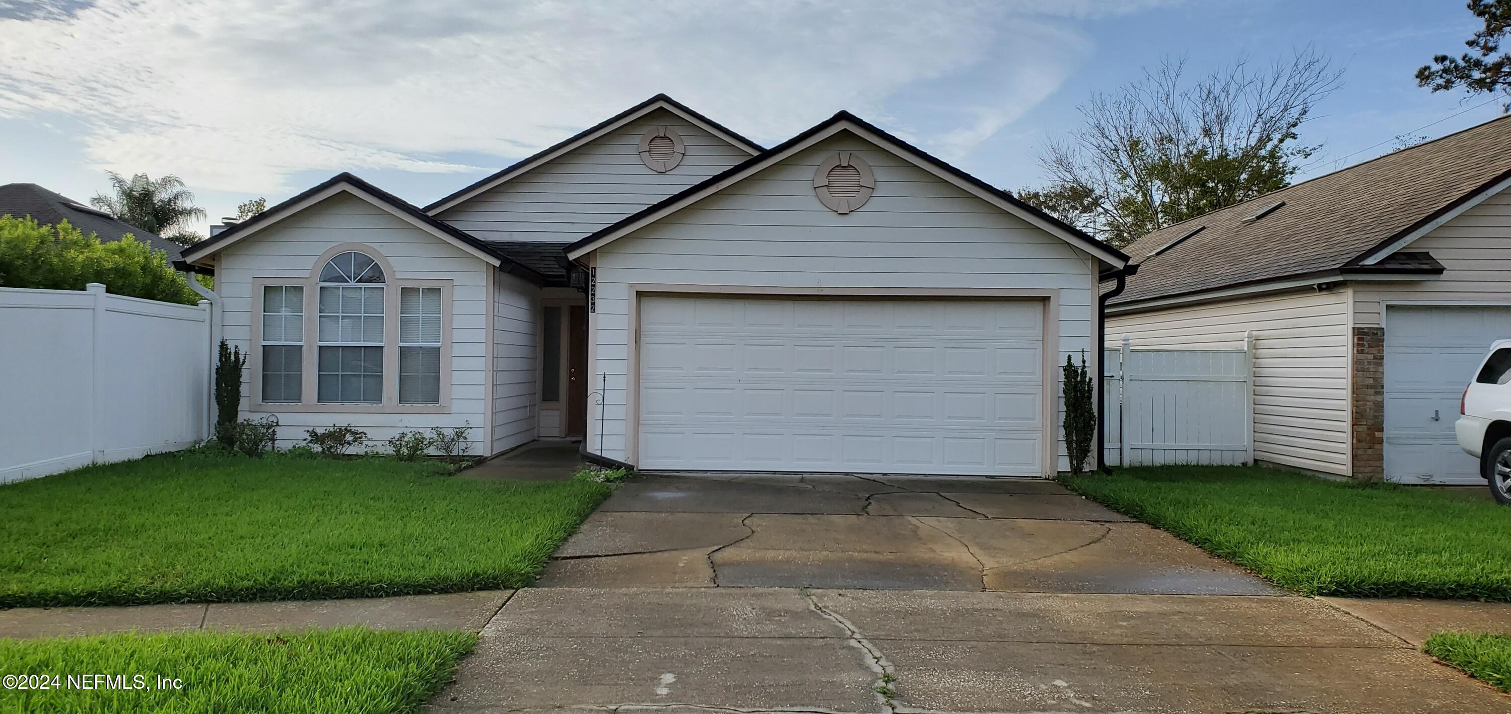 a front view of a house with a garden and yard