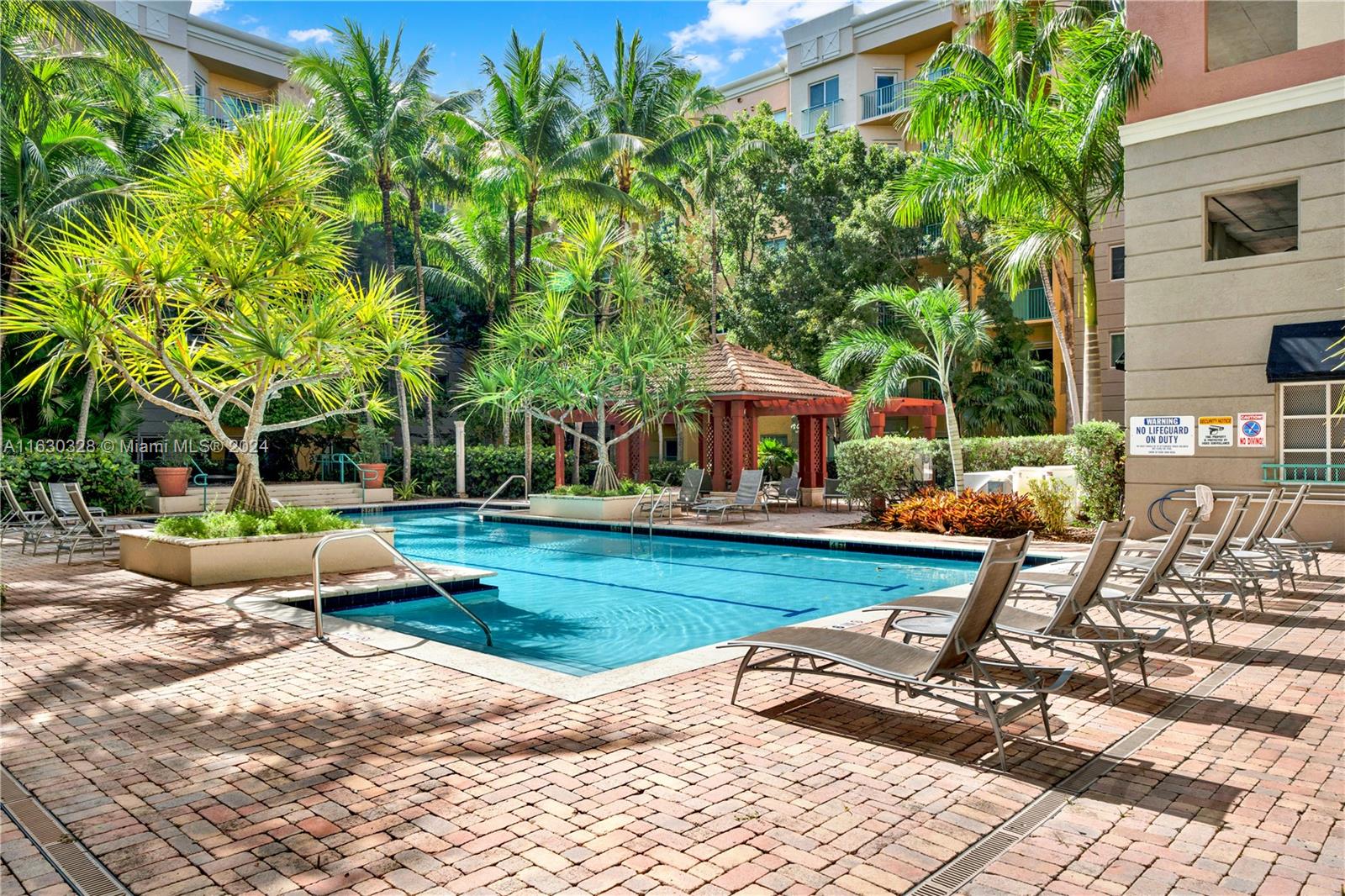 a view of swimming pool with lawn chairs and plants