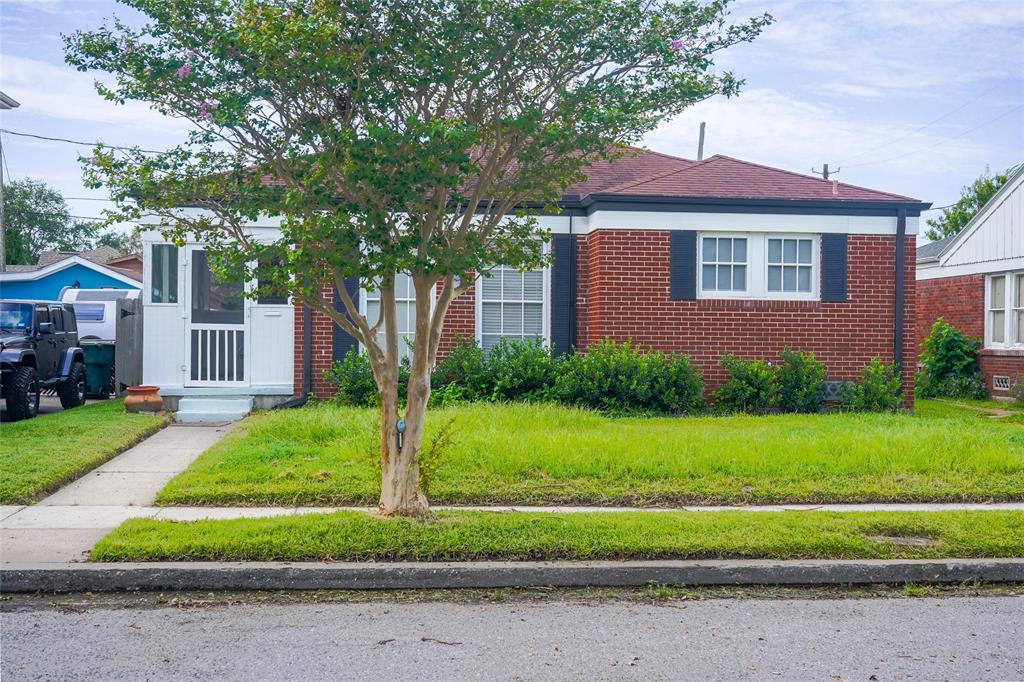 a front view of a house with a yard and trees