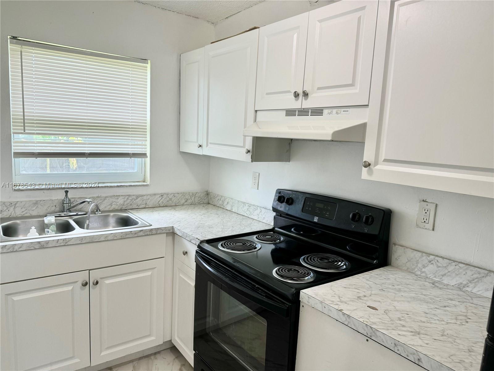 a kitchen with white cabinets and appliances