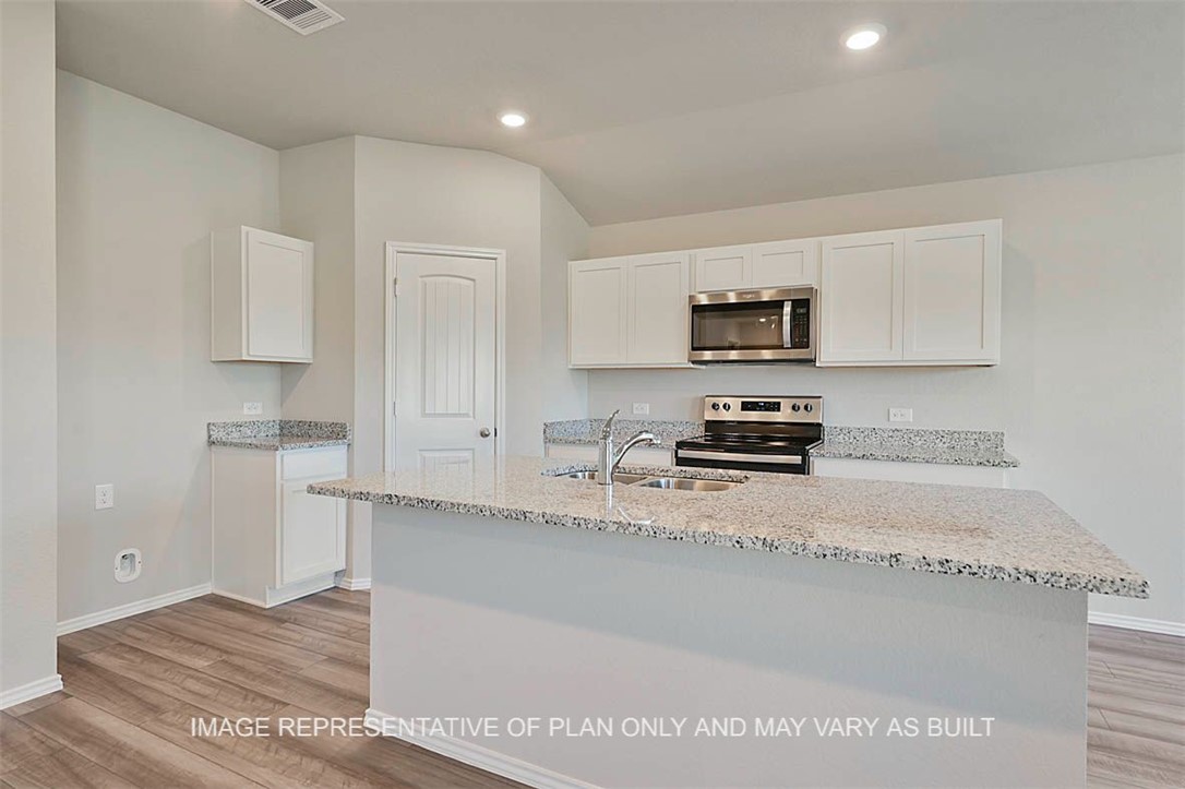 Kitchen featuring white cabinets, appliances with