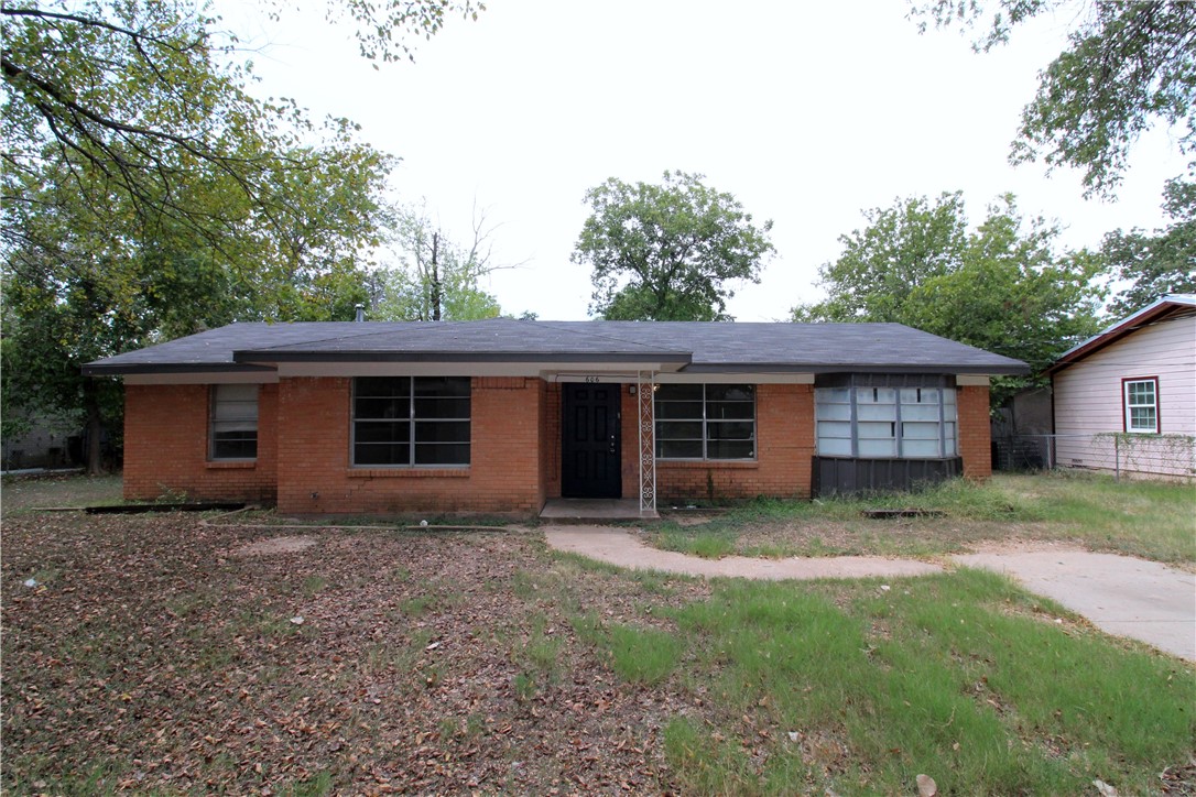 a view of a house with a backyard and a large tree