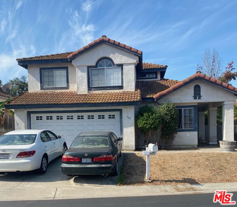 a front view of a house with cars