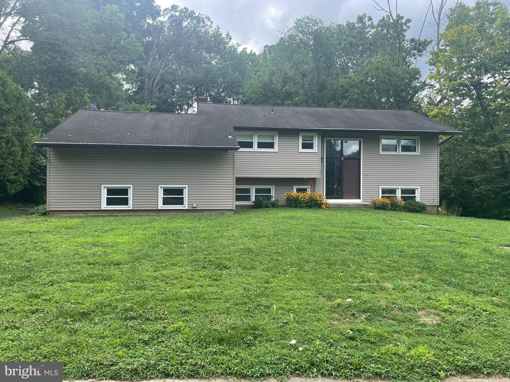 a front view of a house with a yard and trees