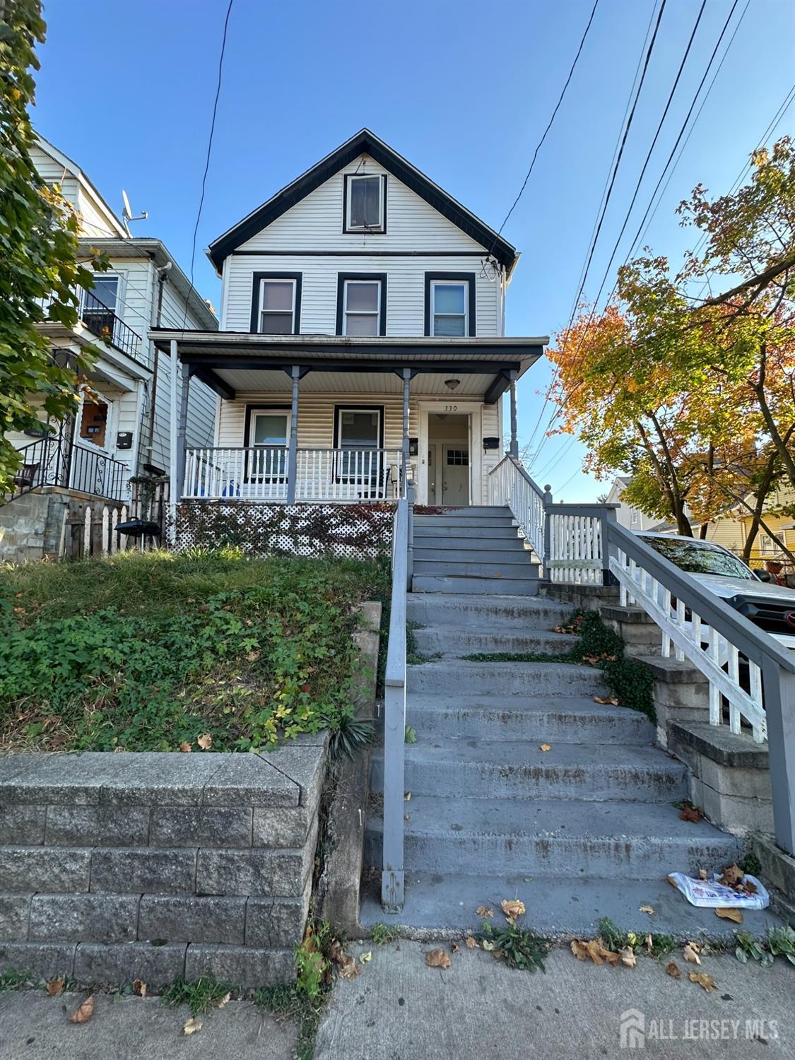 a view of a big house with wooden fence