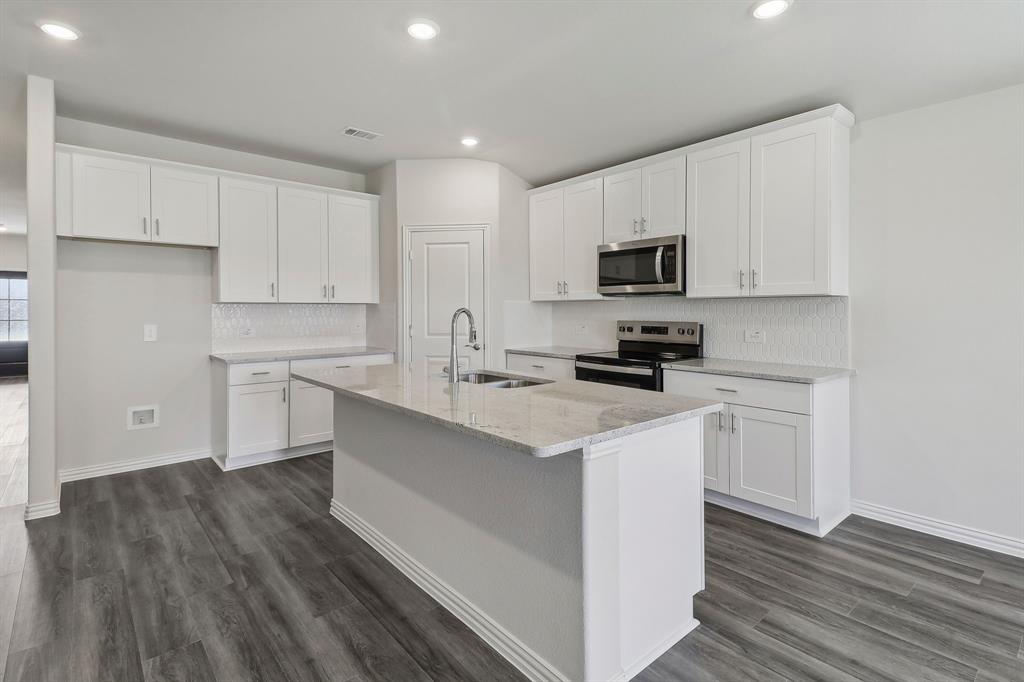 a kitchen with a sink a stove and cabinets