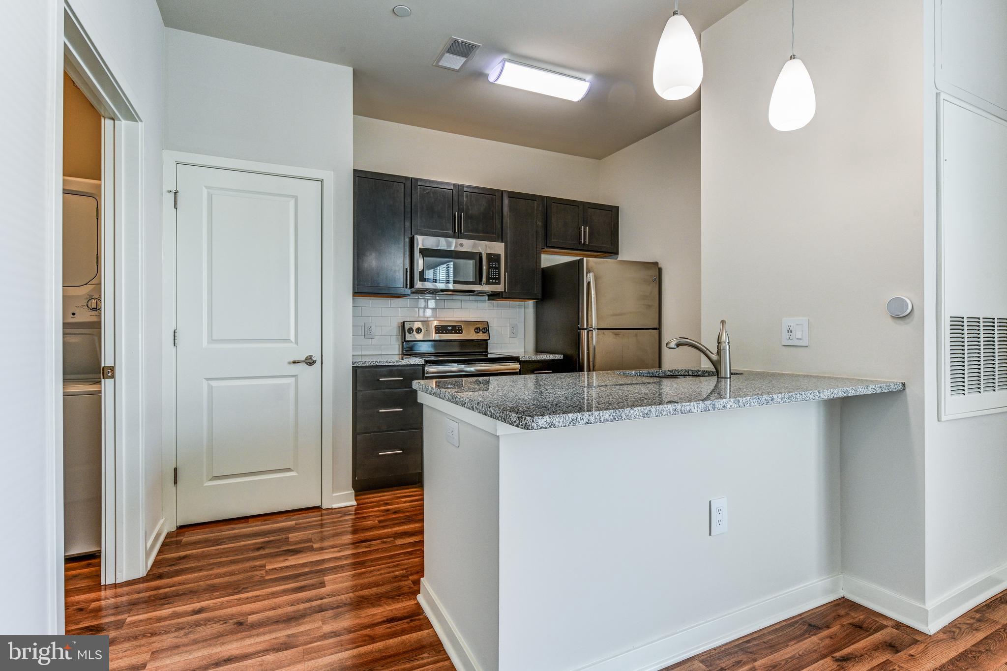 a kitchen with stainless steel appliances granite countertop a refrigerator and a sink