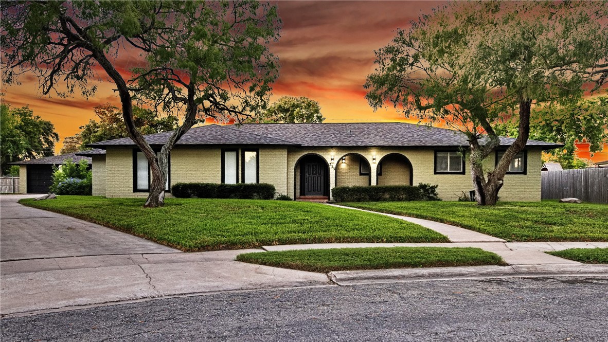 a front view of a house with yard and green space