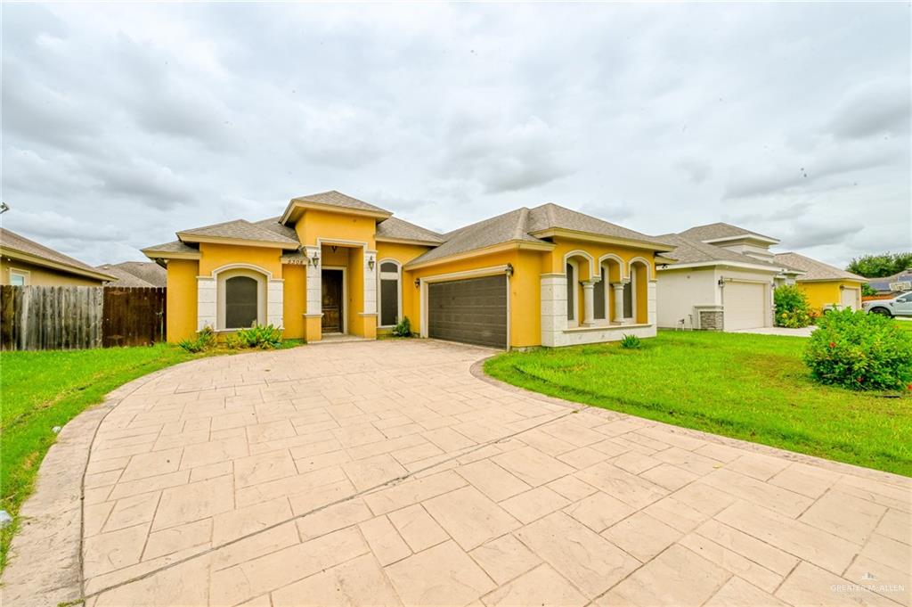 Mediterranean / spanish home with a garage and a front lawn