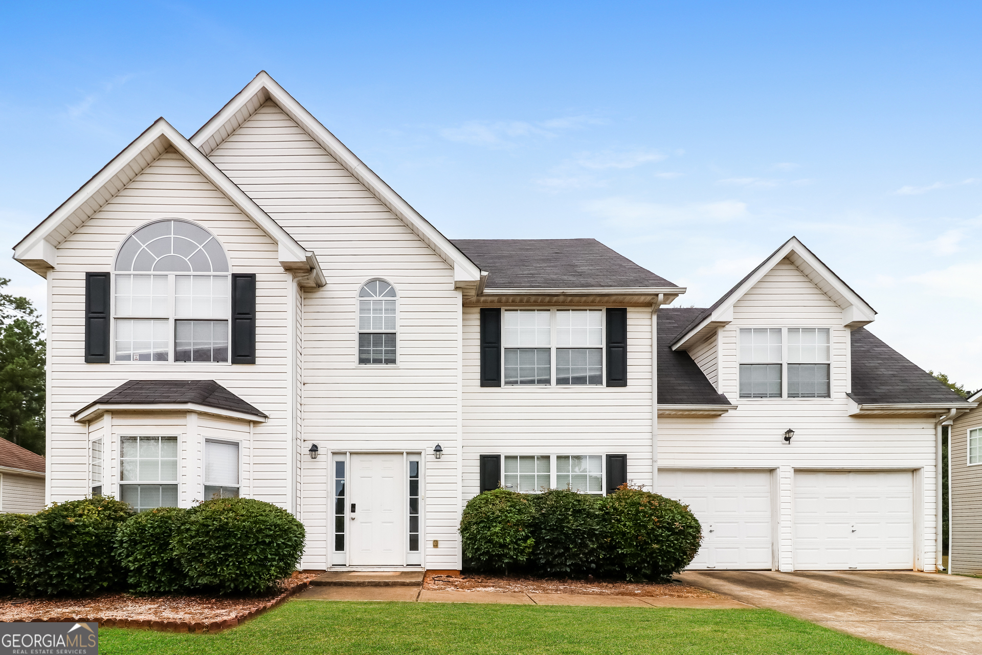 a front view of a house with a yard and garage