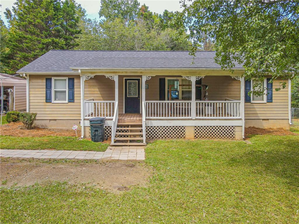 a view of a house with a yard and fence