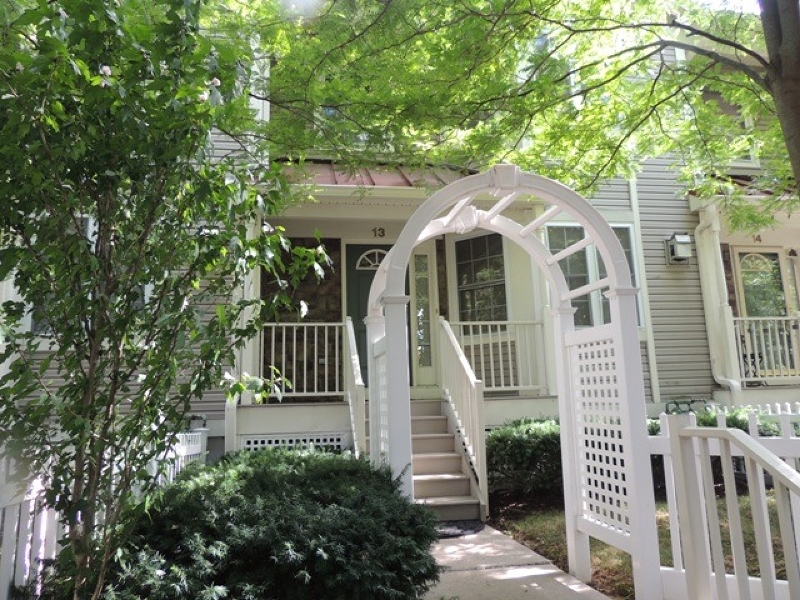 a front view of a house with glass windows and plants