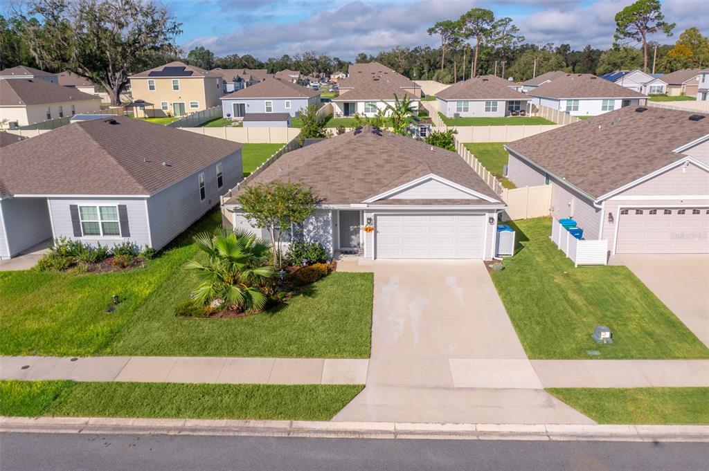 a aerial view of a house with a yard and potted plants