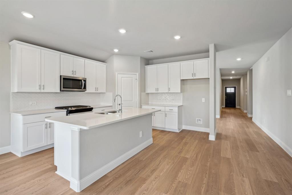 a kitchen with a stove a sink and a refrigerator