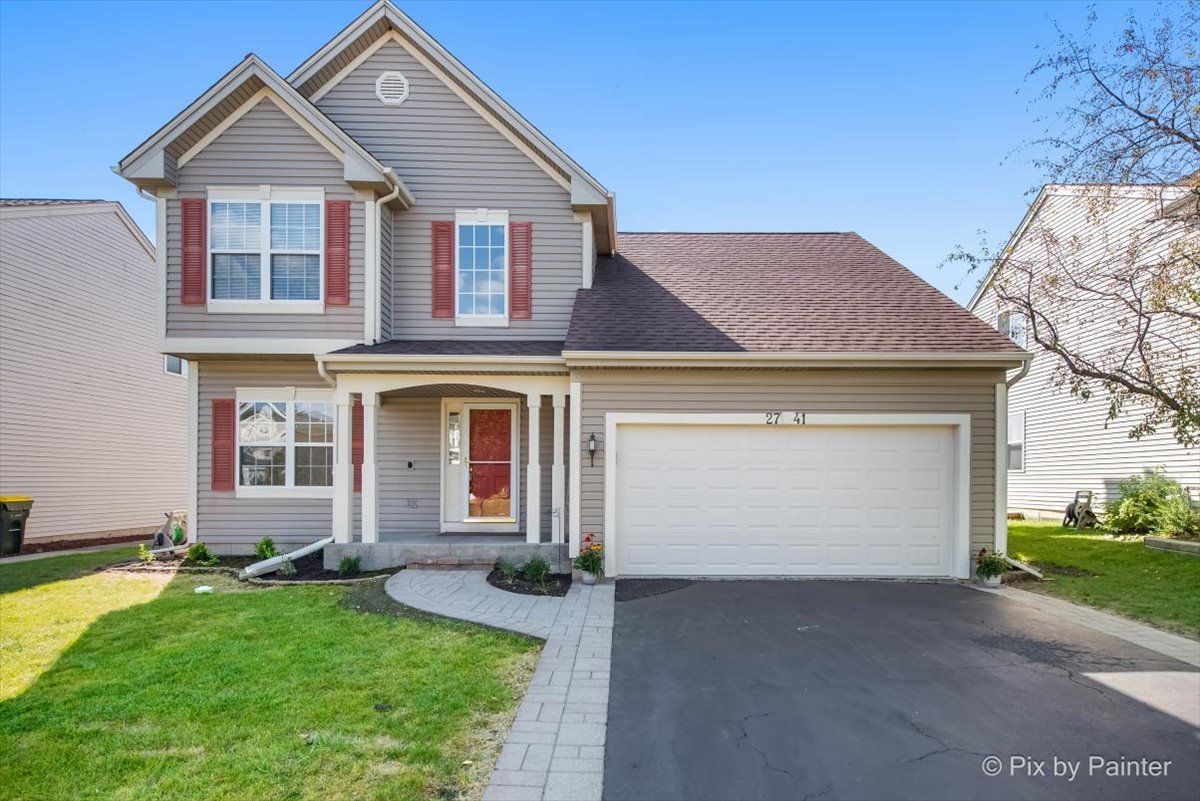 a front view of a house with a yard and garage