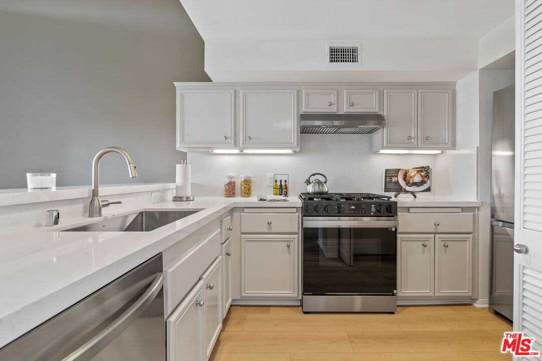 a kitchen with cabinets a sink and appliances