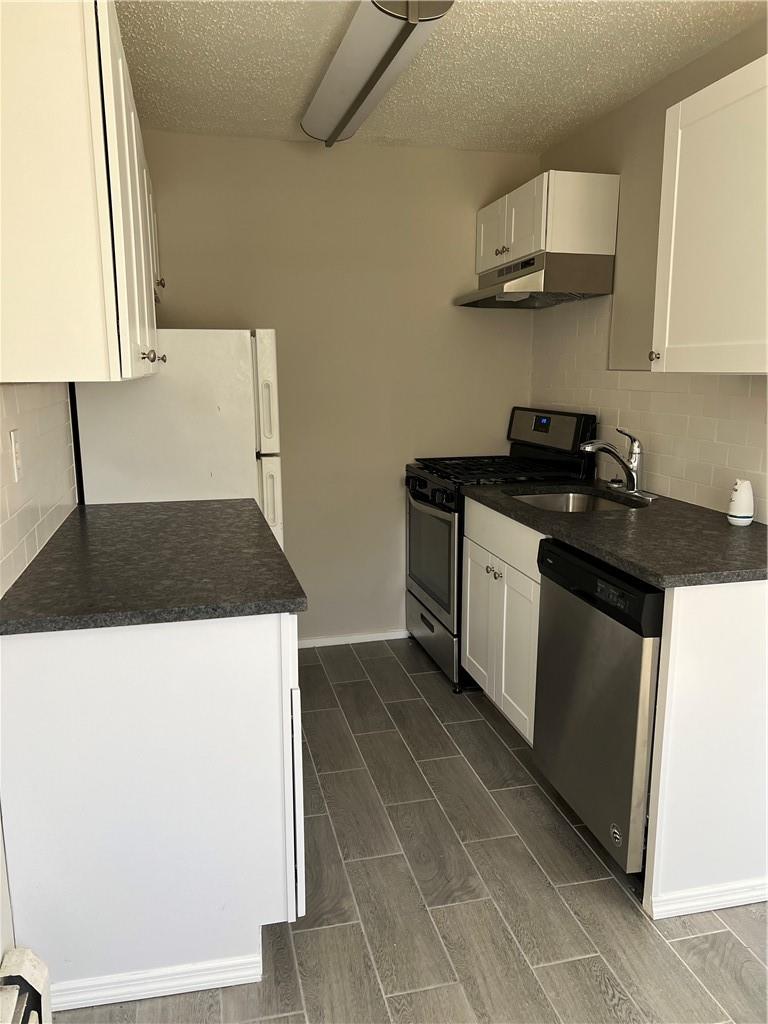 a kitchen with stainless steel appliances a sink stove and cabinets