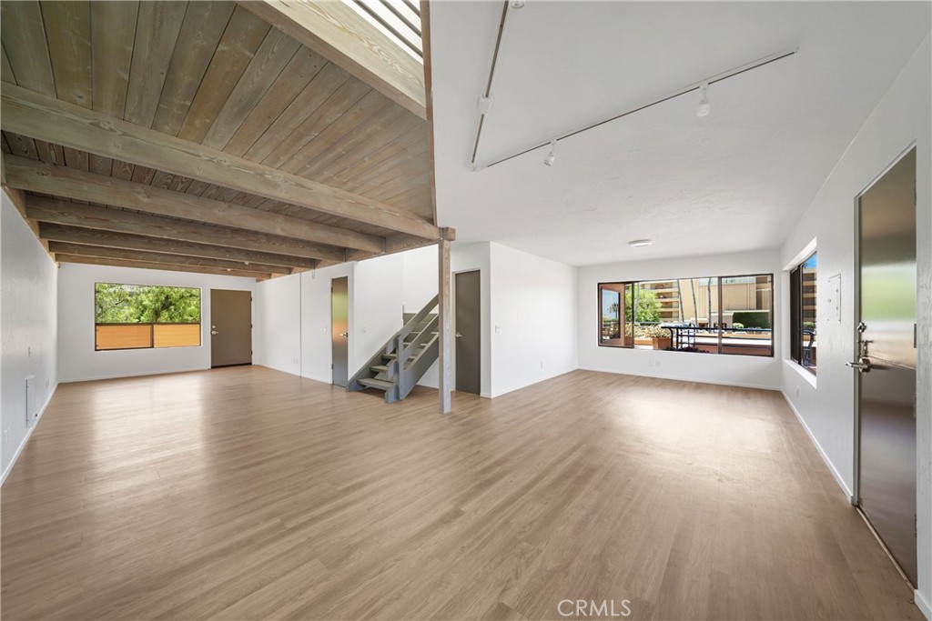 a view of a room window and hardwood floor