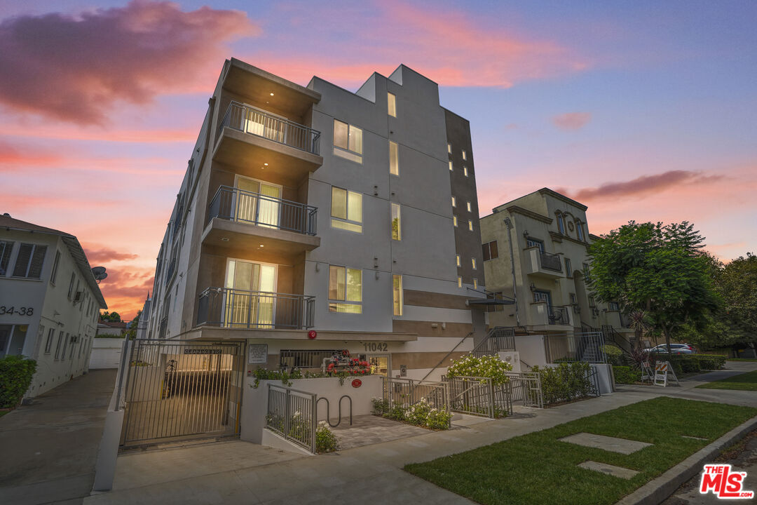 a front view of a residential apartment building with a yard