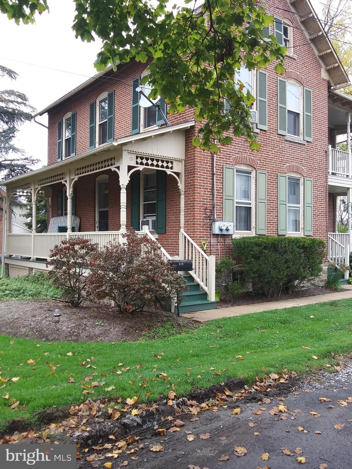 a front view of a house with a yard and trees