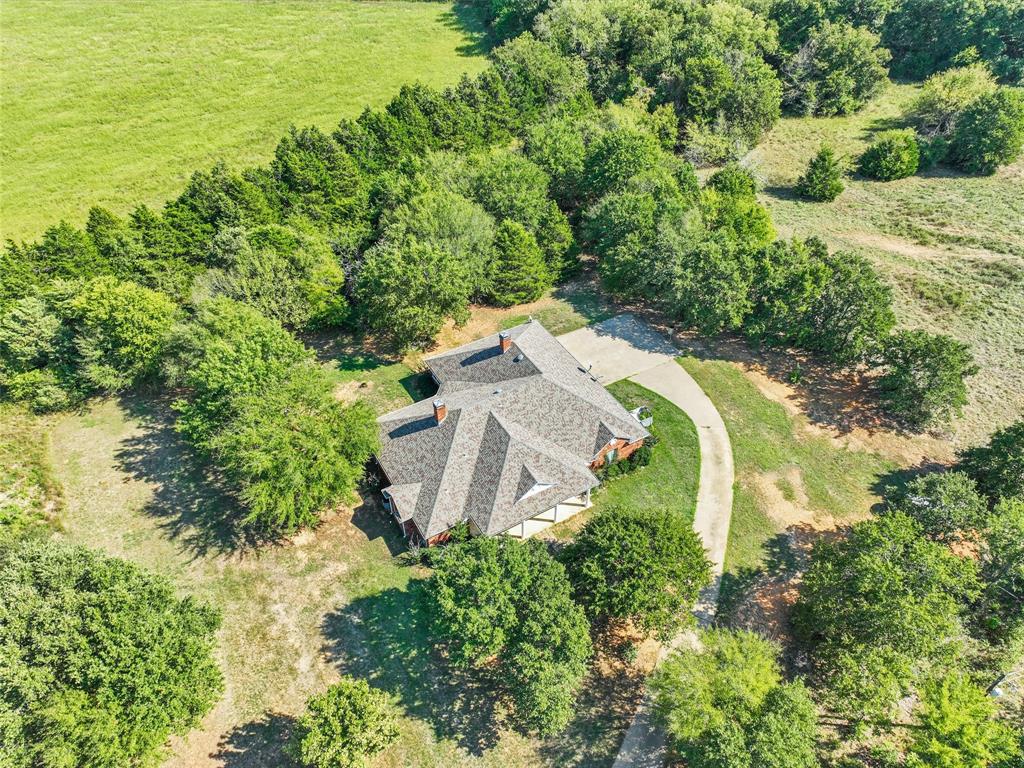 an aerial view of a house with a yard and lake view